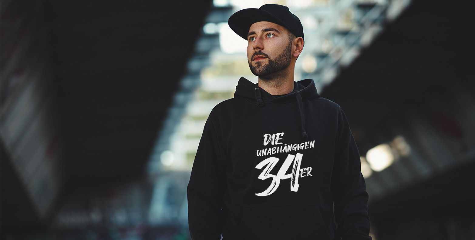 #DIE34ER Hoodies: Ein junger Mann trägt den schwarzen, stylischen #DIE34ER Hoodie