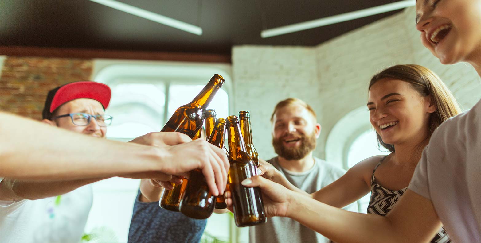#DIE34ER Community Treff - junge Leute in der Finanzbranche stoßen fröhlich mit einem Getränk an